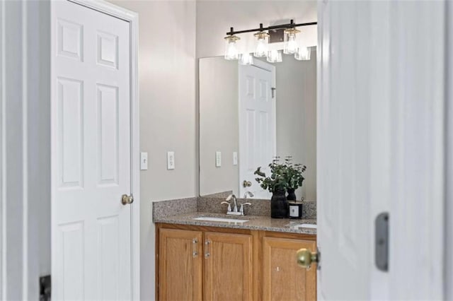 bathroom featuring double vanity, a sink, toilet, and baseboards