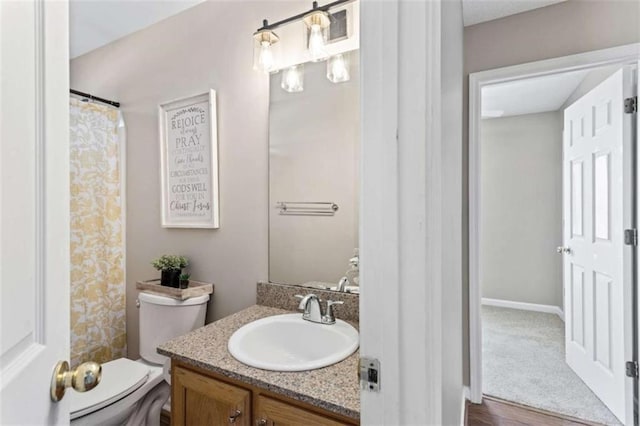 full bathroom with curtained shower, vanity, and toilet