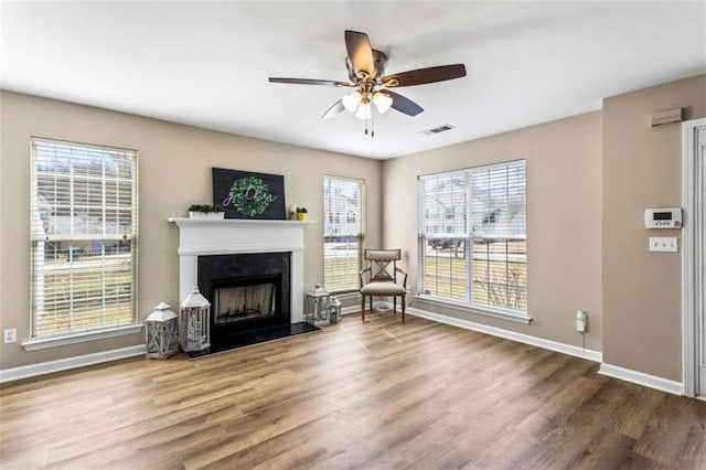 sitting room featuring a fireplace, wood finished floors, visible vents, and baseboards