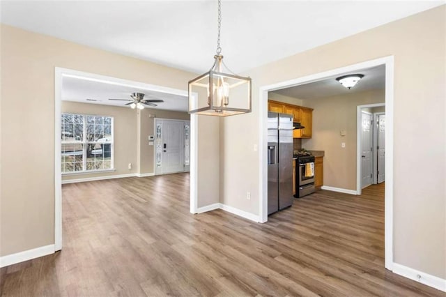 kitchen with stainless steel appliances, wood finished floors, and baseboards