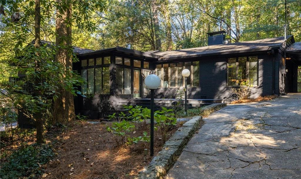 922 Barton Woods Rd NE, Atlanta, GA 30307 - exterior space with a sunroom, driveway, and a chimney