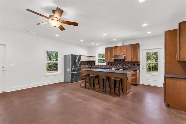 618 W Glade Creek Rd, Clarkesville, GA 30523 - kitchen with freestanding refrigerator, under cabinet range hood, dark countertops, backsplash, and finished concrete floors
