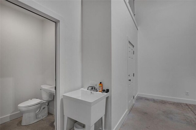 618 W Glade Creek Rd, Clarkesville, GA 30523 - half bathroom featuring concrete flooring, toilet, baseboards, and a sink