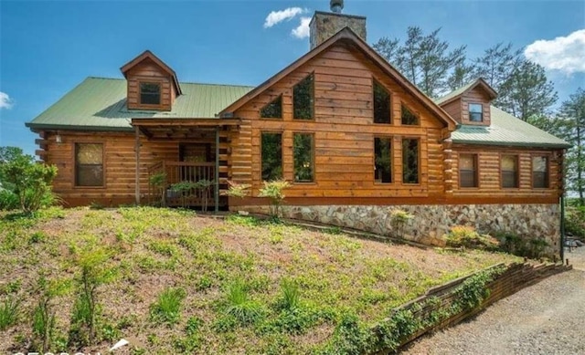 rear view of property featuring metal roof and log exterior