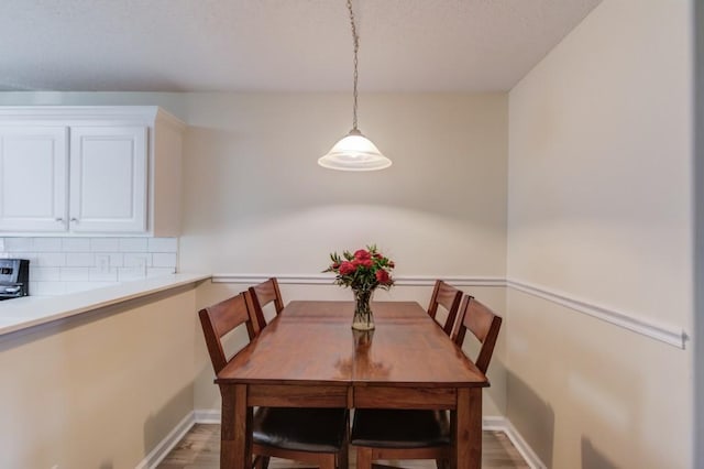 dining room with baseboards and wood finished floors