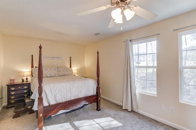 bedroom featuring carpet flooring, multiple windows, baseboards, and ceiling fan