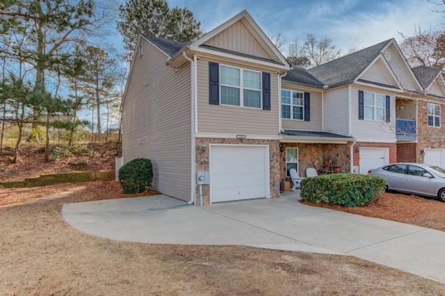 view of front of home with a garage, stone siding, board and batten siding, and driveway