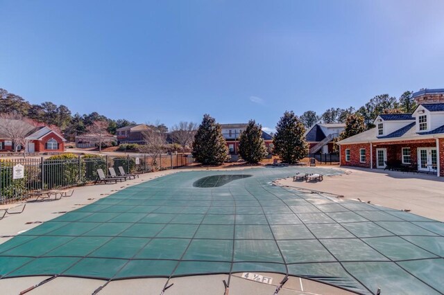 community pool featuring a patio area, a residential view, and fence