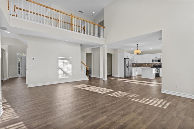 unfurnished living room with dark wood finished floors and baseboards