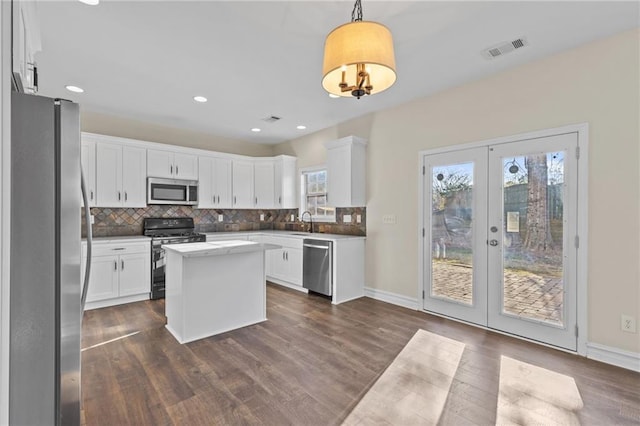 kitchen featuring tasteful backsplash, visible vents, appliances with stainless steel finishes, dark wood-style floors, and white cabinets