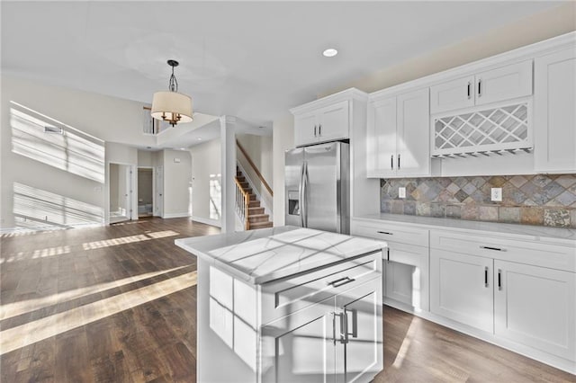 kitchen featuring white cabinets, dark wood-style floors, stainless steel fridge, and backsplash