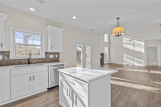 kitchen featuring plenty of natural light, a sink, decorative backsplash, dishwasher, and open floor plan