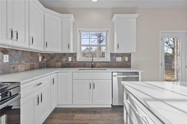 kitchen with stainless steel dishwasher, black electric range, white cabinets, and a sink