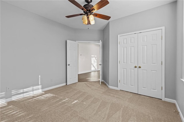 unfurnished bedroom with carpet, baseboards, a closet, and ceiling fan