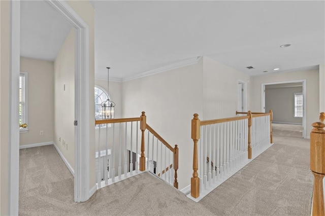 hallway featuring an upstairs landing, plenty of natural light, baseboards, and carpet floors