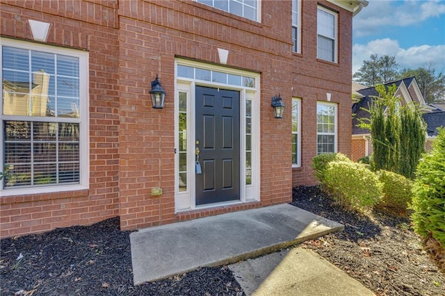 entrance to property featuring brick siding