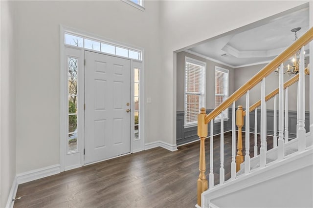 foyer entrance featuring wood finished floors, a healthy amount of sunlight, and ornamental molding