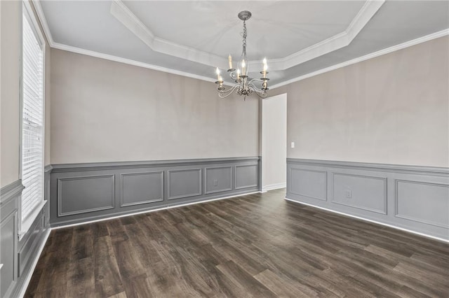 unfurnished dining area with a notable chandelier, ornamental molding, a tray ceiling, and dark wood-style flooring