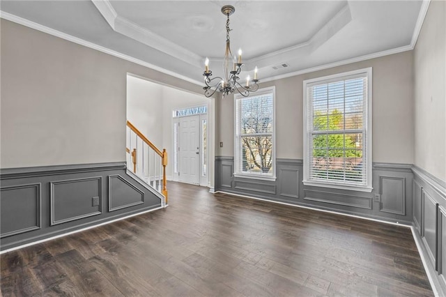 entryway with visible vents, a tray ceiling, dark wood finished floors, an inviting chandelier, and stairs