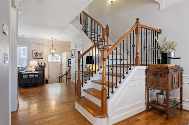 staircase with a chandelier and wood finished floors