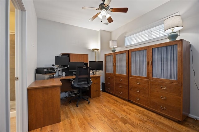 office area with light wood-style floors and ceiling fan