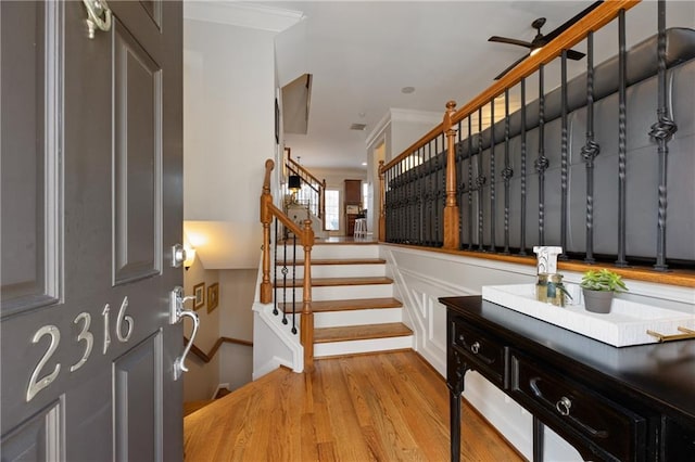 entryway with ornamental molding, stairway, light wood finished floors, and a ceiling fan