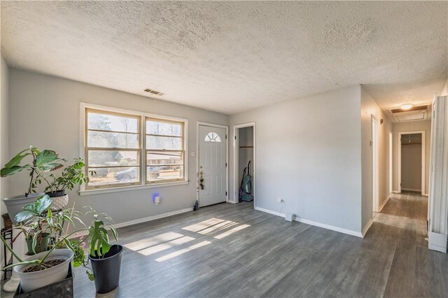 unfurnished room with a textured ceiling and dark hardwood / wood-style floors