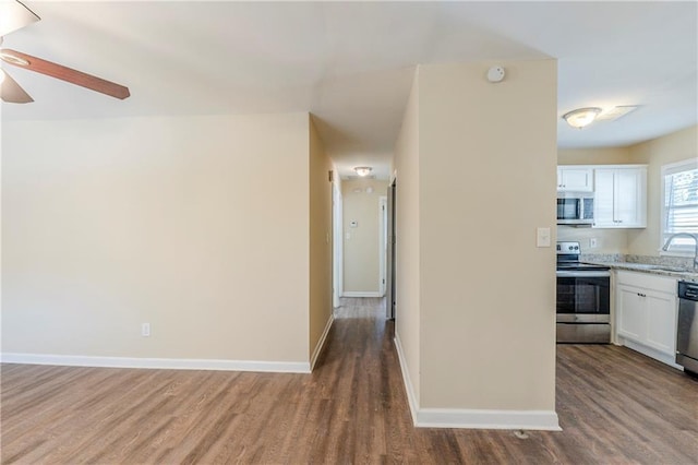 kitchen featuring appliances with stainless steel finishes, hardwood / wood-style floors, sink, white cabinets, and ceiling fan