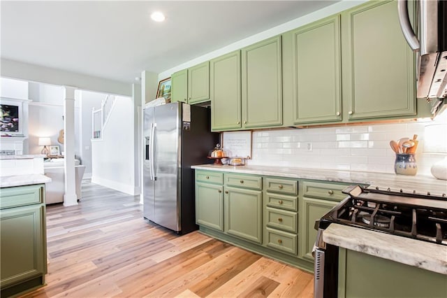 kitchen with green cabinets, appliances with stainless steel finishes, light wood finished floors, tasteful backsplash, and recessed lighting