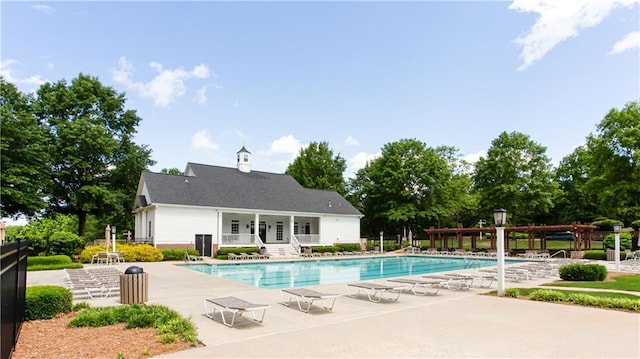 community pool featuring a pergola, a patio, fence, and an outbuilding