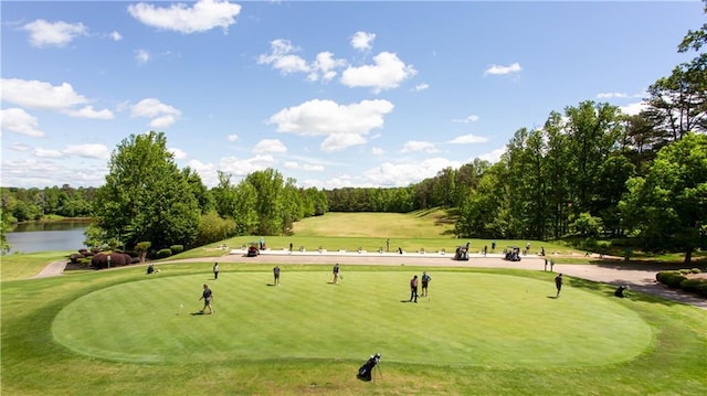 view of home's community featuring view of golf course, a water view, and view of wooded area