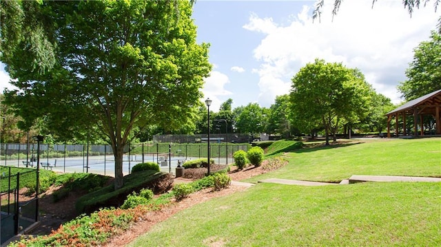 view of property's community featuring a tennis court