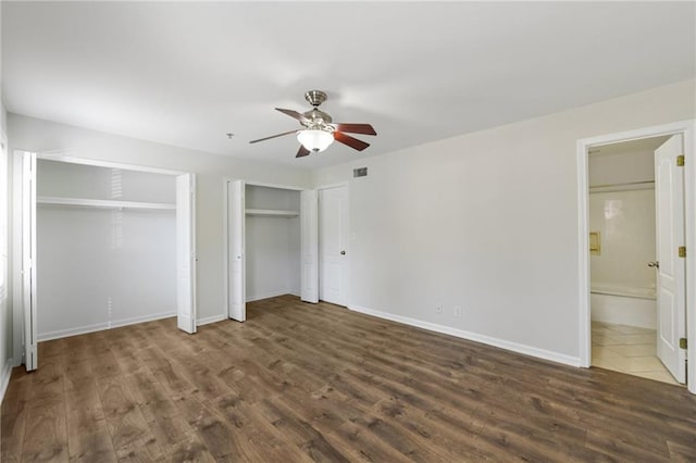 2825 NE Expy NE Unit F003, Atlanta, GA 30345 - unfurnished bedroom with wood finished floors, two closets, connected bathroom, and a ceiling fan