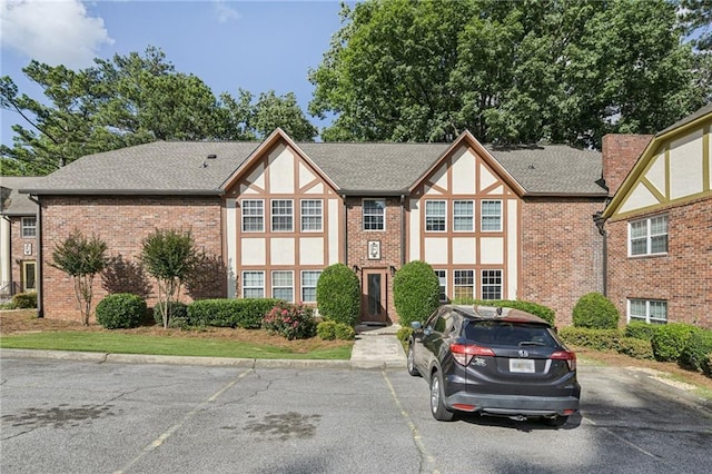 2825 NE Expy NE Unit F003, Atlanta, GA 30345 - tudor-style house featuring uncovered parking and brick siding