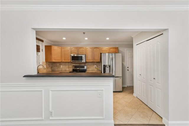 2825 NE Expy NE Unit F003, Atlanta, GA 30345 - kitchen with stainless steel appliances, dark countertops, decorative backsplash, a peninsula, and light tile patterned flooring
