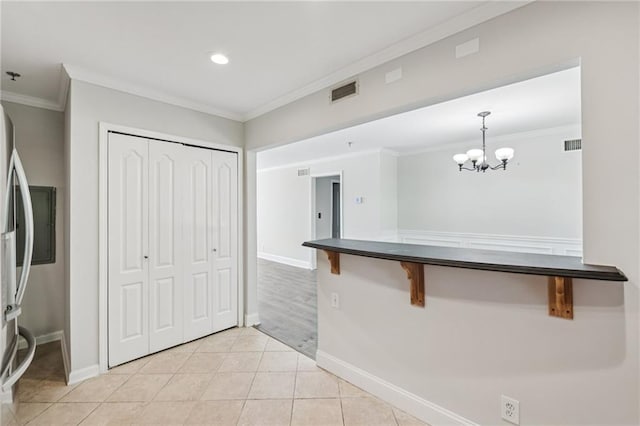 2825 NE Expy NE Unit F003, Atlanta, GA 30345 - kitchen featuring crown molding, a kitchen bar, a chandelier, light tile patterned floors, and dark countertops