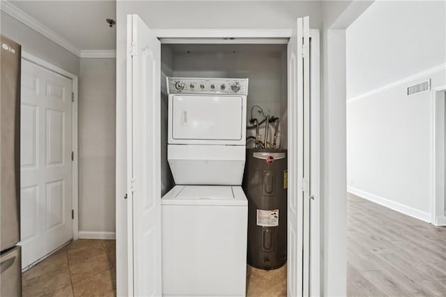 2825 NE Expy NE Unit F003, Atlanta, GA 30345 - laundry area featuring stacked washer and clothes dryer, water heater, and ornamental molding