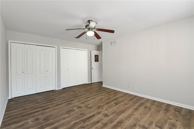 2825 NE Expy NE Unit F003, Atlanta, GA 30345 - unfurnished bedroom featuring multiple closets, dark wood-type flooring, and ceiling fan