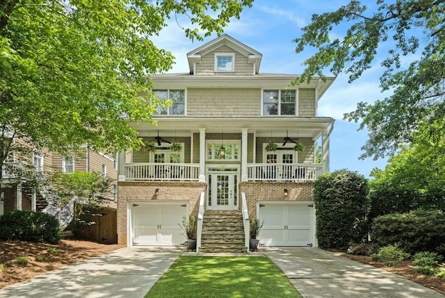 view of front facade featuring stairs, concrete driveway, an attached garage, and a ceiling fan
