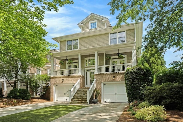 view of front of property with ceiling fan, stairs, covered porch, and a garage