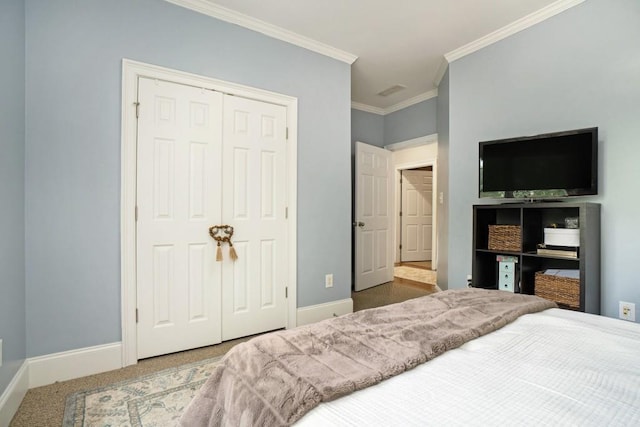 carpeted bedroom with ornamental molding, a closet, and baseboards