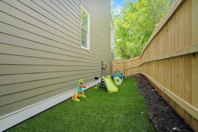 view of yard with fence and a playground