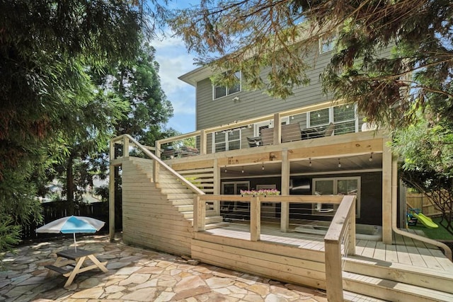 back of house featuring a patio, a deck, fence, and stairway