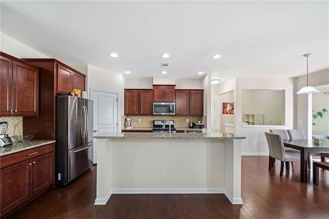 kitchen with appliances with stainless steel finishes, decorative backsplash, light stone countertops, dark wood finished floors, and recessed lighting