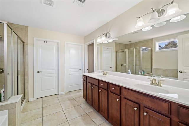 bathroom featuring a stall shower, tile patterned floors, and double vanity