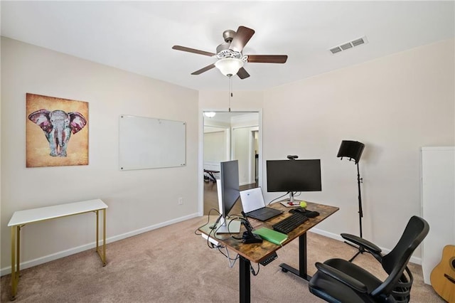 home office with a ceiling fan, light carpet, and baseboards