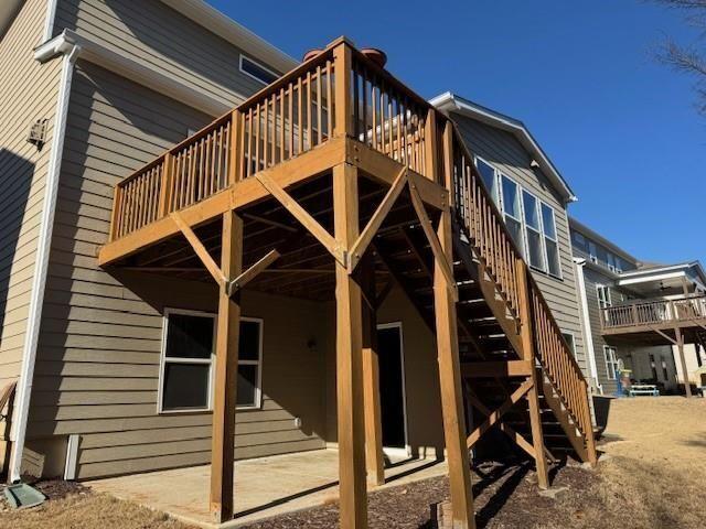back of property with a wooden deck and stairs