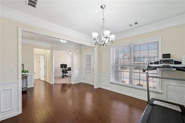 dining room with an office area, hardwood / wood-style flooring, a chandelier, ornamental molding, and a wainscoted wall