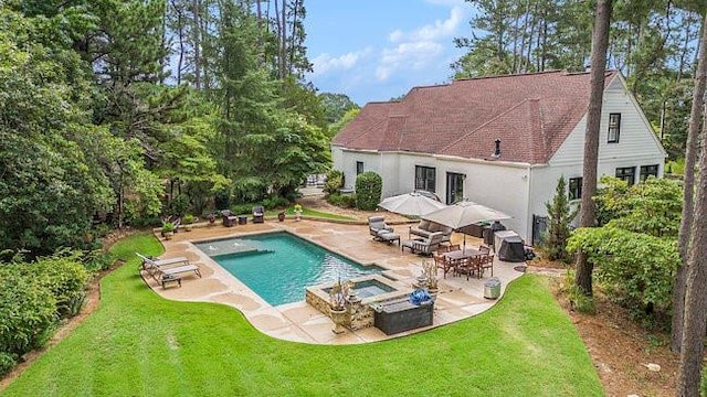 view of pool featuring a lawn and a patio