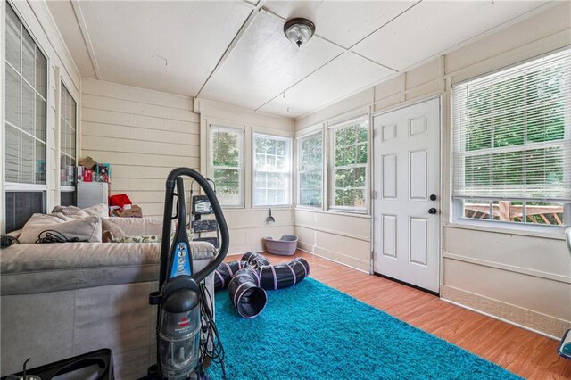 exercise area with wood finished floors, baseboards, and wood walls
